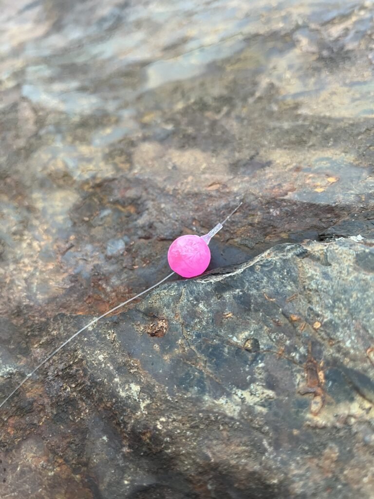 Fluorescent Pink Mottled Bead on rock