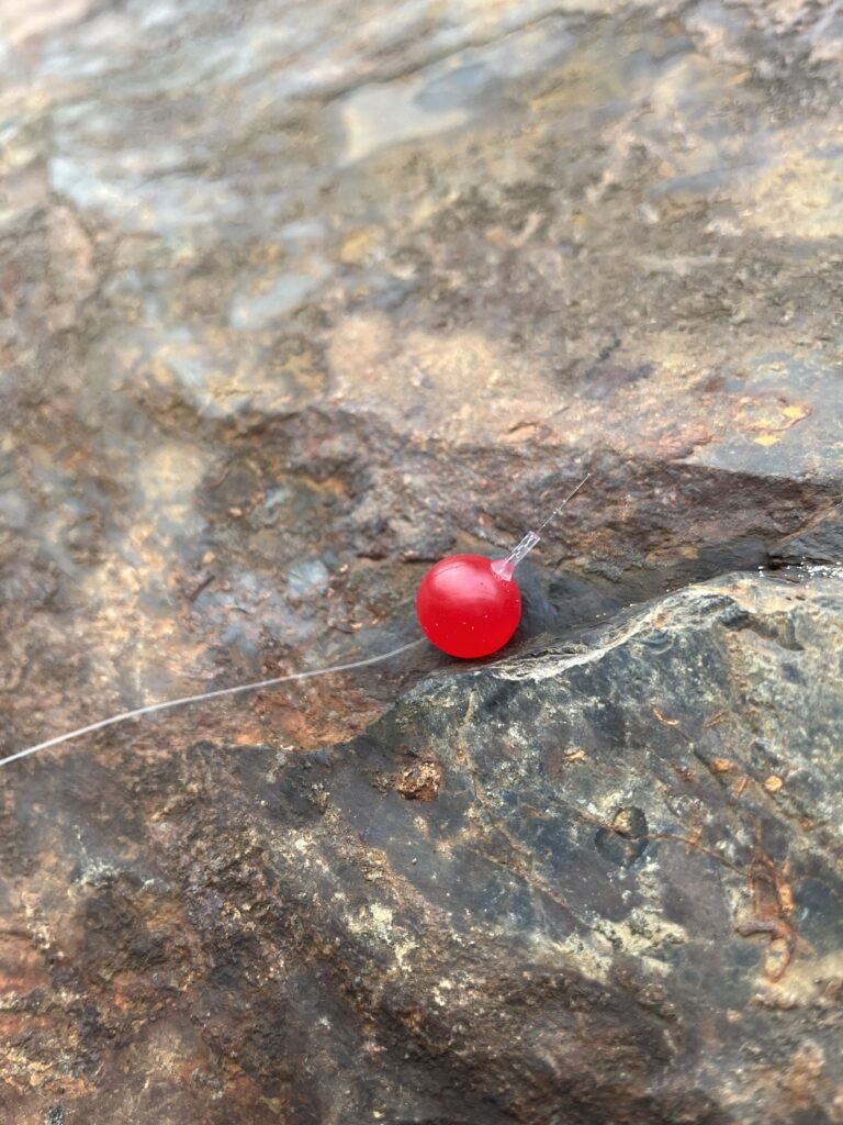 Maroon Red Soft Bead on rock